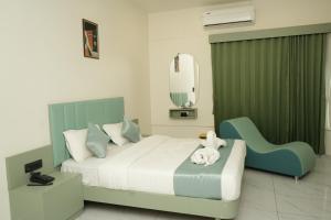 a hotel room with a bed and a chair at Hotel Bandhan in Himatnagar