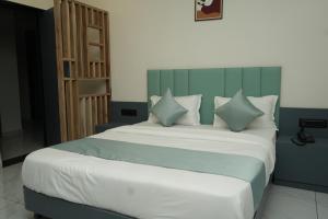 a bedroom with a large white bed with pillows at Hotel Bandhan in Himatnagar +10 photos
