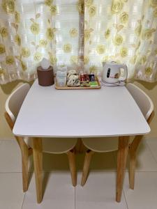 a white table and chairs with a tea pot on it at บ้านสวนบรรจงอักษร Bansuan Banjong Akkson in Rayong