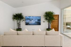 a living room with a couch and two potted plants at Modern Private Pool Villa - 3BR - Koh Phangan in Ko Phangan