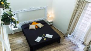 - une petite chambre avec un lit noir et des oreillers dans l'établissement Mimì, à Gaète
