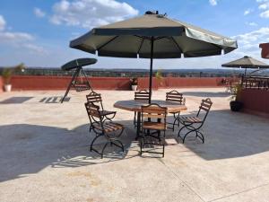 a table and chairs under an umbrella on a patio at HomePlug Realty in Ongata Rongai 