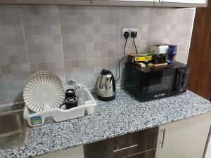 a kitchen counter with a coffee maker and a microwave at HomePlug Realty in Ongata Rongai 