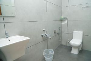 a bathroom with a sink and a toilet and a shower at Le Sancta homestay in Maraiyūr