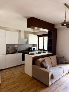 a living room with a couch and a kitchen at Maison Piave 35 in Olbia