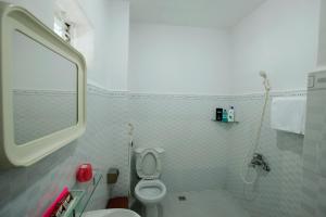 a white bathroom with a toilet and a shower at Tan Da Hotel in Ho Chi Minh City