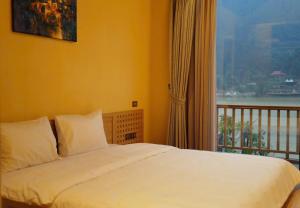 a bedroom with a bed and a window with a view at Anvi Haven in Sóc Sơn
