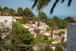 a village on a hill with houses and trees at CBA COSTA BRAVA - Cala Morisca in Tossa de Mar