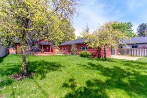 a red house with a yard with a tree at The Hangout House With Bonus Game Room & Foosball in Coeur d'Alene +21 photos