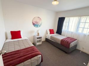 a bedroom with two beds and a window at Settlers Motor Lodge in Lower Hutt
