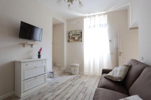 ein Wohnzimmer mit einem Sofa und einem TV in der Unterkunft Ambrosio Relais in Sorrent