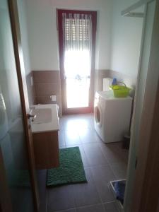 a bathroom with a sink and a washing machine at Alloggio per 4 persone con due camere da letto e cucina in Carrù +34 photos