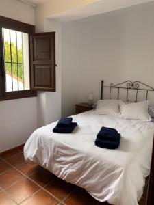a bedroom with a bed with two blue towels on it at Hostel Los Guajares in Guájar-Faragüit