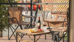 a table with a bottle of wine and two chairs at Chaesonghwa Glamping in Yeongcheon in Yeongcheon