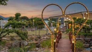 a wooden walkway leading through a garden with arch gates at Chaesonghwa Glamping in Yeongcheon in Yeongcheon +3 photos