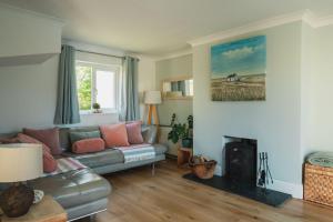 a living room with a couch and a fireplace at Driftwood in Croyde