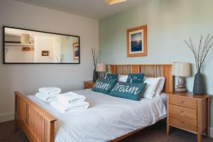 a bedroom with a bed with towels on it at Driftwood in Croyde