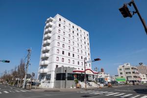 a white building on the corner of a street at KOKO STAY Miyakonojo in Miyakonojō