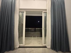 a room with a large window with a view at Kodai Square Homestay in Kodaikānāl