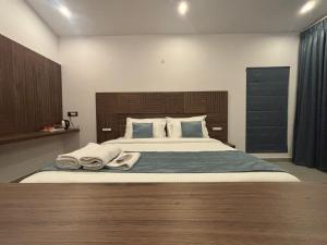 a bedroom with a large bed with towels on it at Kodai Square Homestay in Kodaikānāl