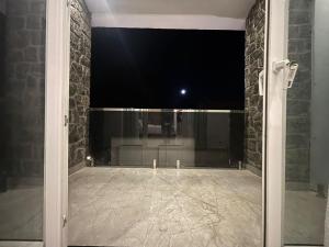 a room with a glass door with a stone wall at Kodai Square Homestay in Kodaikānāl +11 photos
