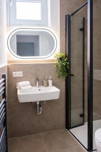 a bathroom with a sink and a mirror at Sindelfingen Apartments in Sindelfingen