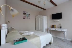 a bedroom with two beds and a desk and a television at Ambrosio Relais in Sorrento