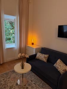 a living room with a black couch and a table at La Villa Lopud- Breakfast & Dinner Included in Lopud +84 photos