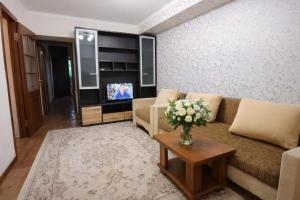 a living room with a couch and a tv at Апартамент возле аэропорта in Almaty