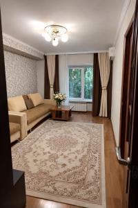 a living room with a couch and a table at Апартамент возле аэропорта in Almaty