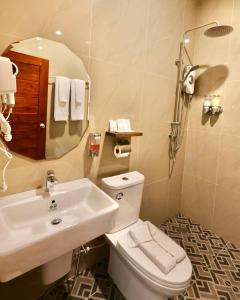 a bathroom with a sink and a toilet and a mirror at KL Dawarika Mali Hotel in Ban Tai +19 photos