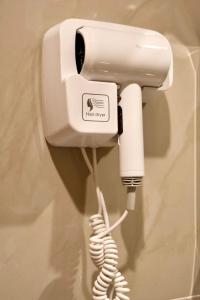 a white phone hanging on a wall with a cord at KL Dawarika Mali Hotel in Ban Tai