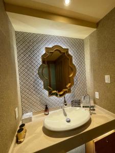 ein Badezimmerwaschbecken mit einem großen Spiegel an der Wand in der Unterkunft hotel evi tower 大人専用 in Toda