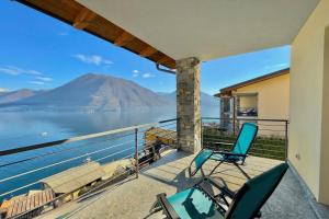 a balcony with two chairs and a view of a mountain at Residence degli Oleandri 4B in Argegno