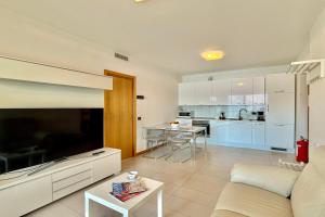 a living room with a couch and a kitchen at Residence degli Oleandri 4B in Argegno