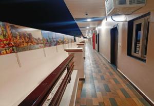 a hallway with benches and paintings on the walls at Hotel Assi Retreat in Varanasi