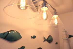 a chandelier hanging from a ceiling with fish on it at Lighthouse cottage in Watchet +19 photos
