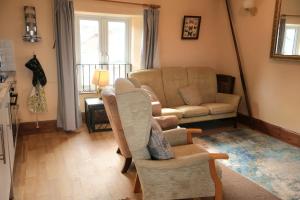 a living room with a couch and a chair at Lighthouse cottage in Watchet