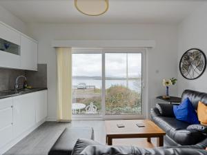 a living room with a view of the ocean at Ards House Self catering apartment with sea views in Oban