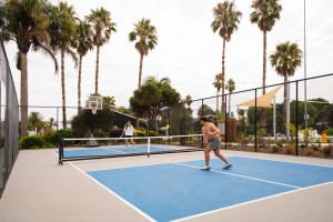 two people playing tennis on a tennis court at Tasman Holiday Parks - Miranda in Miranda