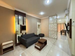 a living room with a couch and a table at MTC Mega Mas Apartment in Manado