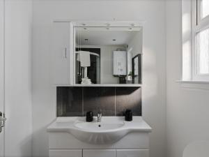 a white bathroom with a sink and a mirror at Ards House Self catering apartment with sea views in Oban +13 photos
