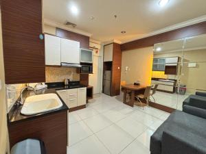 a kitchen and living room with a couch and a table at MTC Mega Mas Apartment in Manado