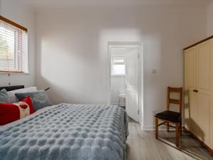 a bedroom with a bed and a chair and a window at Ards House Self catering apartment with sea views in Oban