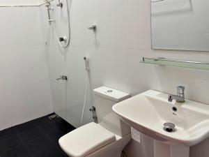 a white bathroom with a toilet and a sink at The Amora in Arugam Bay +70 photos