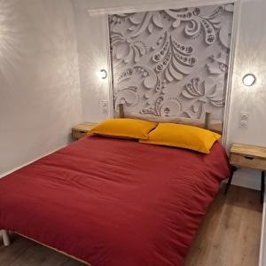 a bedroom with a red bed with yellow pillows at La Mamone in Ornans