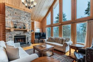 a living room filled with furniture and a stone fireplace at Fiddler Lake Resort - Deer 86 in Mille-Isles