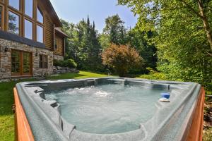 a hot tub in the backyard of a house at Fiddler Lake Resort - Deer 86 in Mille-Isles