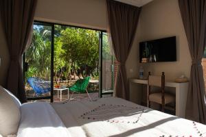 a bedroom with a bed and a view of a patio at Le Bled Ferme in Marrakesh
