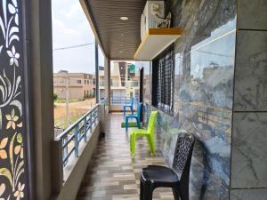a balcony with green and blue chairs at NARGILA HAMPi in Hampi